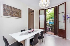 Un coin repas avec une table blanche, des chaises noires et un bol décoratif.