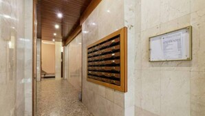 A hallway with a marble floor and a wall-mounted wine rack.