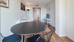 A modern living room with a round dining table, white sofa, and a TV on a white stand. - Stay U-nique Apartments Sants II (Barcelona)