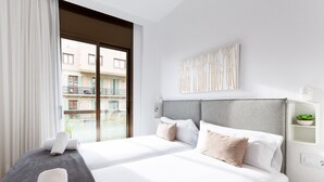 Une chambre d’hôtel avec deux lits, une grande fenêtre et une vue sur un immeuble.
