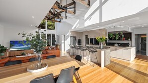 Un espacio habitable moderno y abierto con una mesa de comedor, sofás y una cocina.