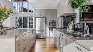 Una cocina moderna con electrodomésticos de acero inoxidable, una isla central y vistas al exterior.