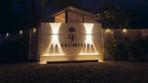 A building with a sign reading "LA PROMETIDA" illuminated by lights.