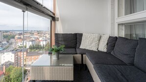 A balcony with a sofa, a small table with a plant, and a city view. - Come in! `Wallesmanni` Best location in Tampere! (Tampere)