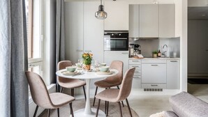 Een moderne keuken met witte kastjes, een zwarte oven en een roestvrijstalen spoelbak.