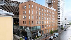 Een meerhoog hotel met een modern gevelontwerp, grote ramen en een duidelijke ingang met een glazen deur.