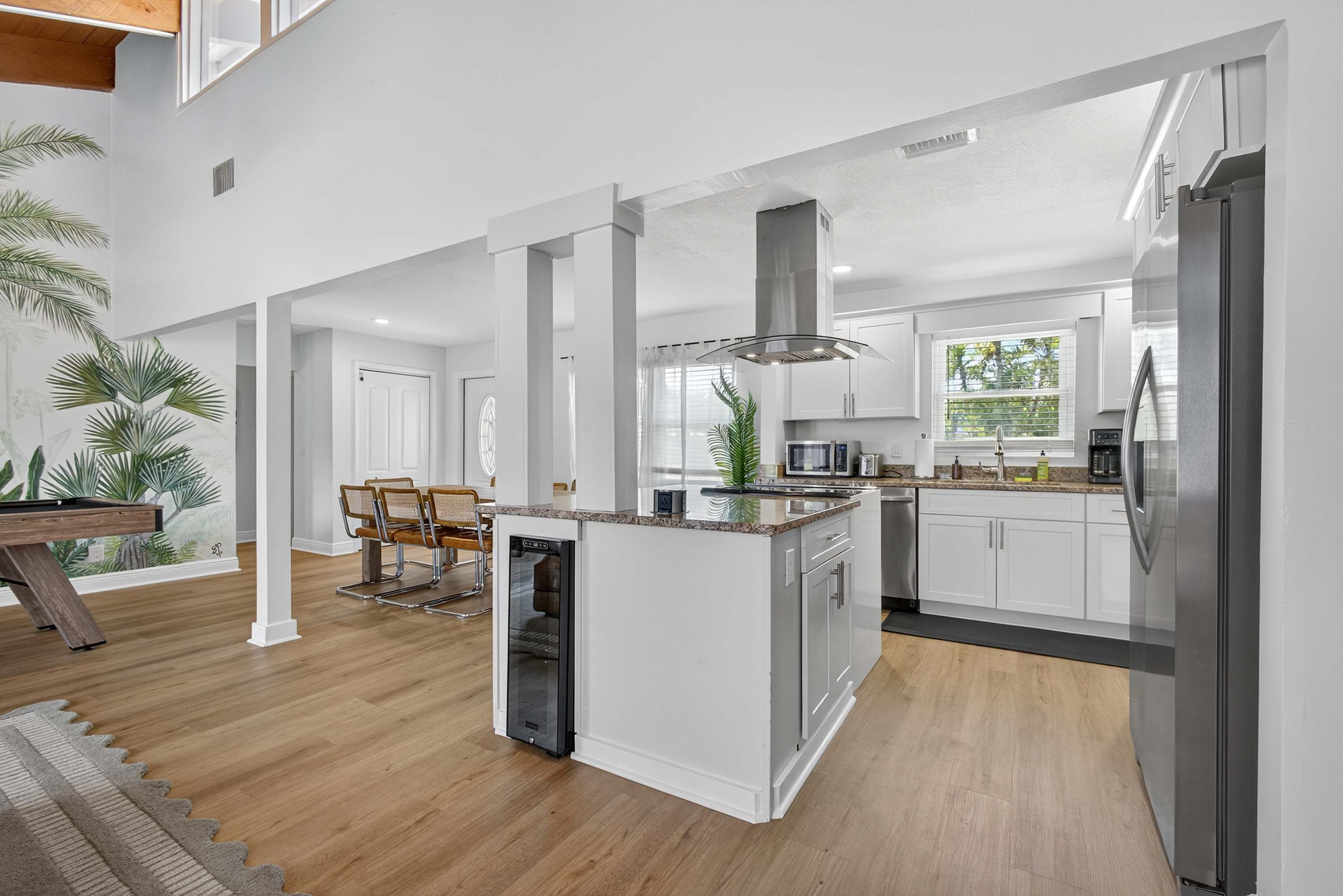 A modern kitchen with white cabinetry, stainless steel appliances, and a central island.