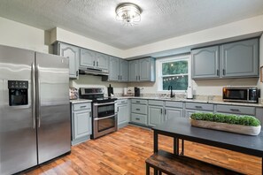 Eine moderne Küche mit grauen Schränken, Edelstahlgeräten und Holzboden.
