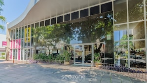 A modern building with a curved facade, large glass windows, and a sign reading "Santorini 460". - Beautiful Apartment With Barbecue in PoA Rps0460 (Porto Alegre)