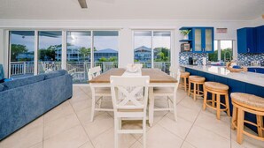 A modern kitchen with a dining area, large windows, and a balcony. - Beautiful two- story beach house (Islamorada)