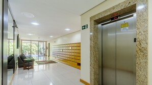 A hotel lobby with a reception desk, seating area, and an elevator. - Elegant Apartment for Couples in Poa-rs Urb1110 (Porto Alegre)
