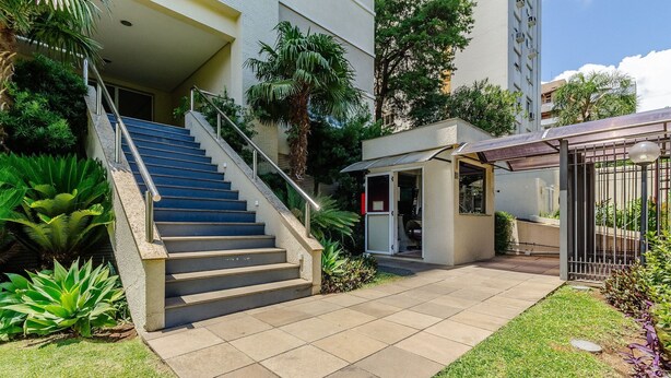 A building with a staircase leading to a door, surrounded by greenery and a small garden area. - Elegant Apartment for Couples in Poa-rs Urb1110 (Porto Alegre)