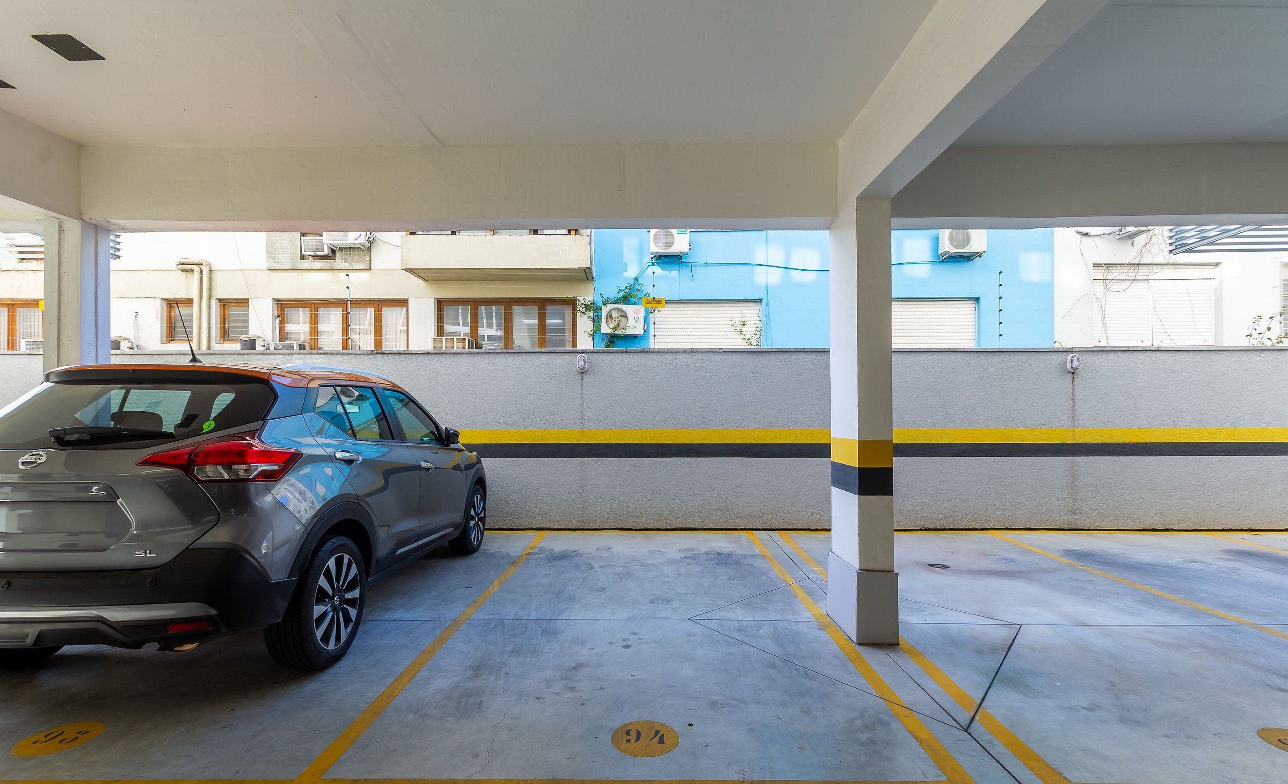 A parking garage with a car parked in a designated spot.