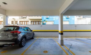 A parking garage with a car parked in a designated spot. - Studio encantador com Garagem em POA VENB504 (Porto Alegre)