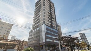 Korkea, moderni rakennus, jossa on useita kerroksia, suuret ikkunat ja huomiota herättävä sisäänkäynti.