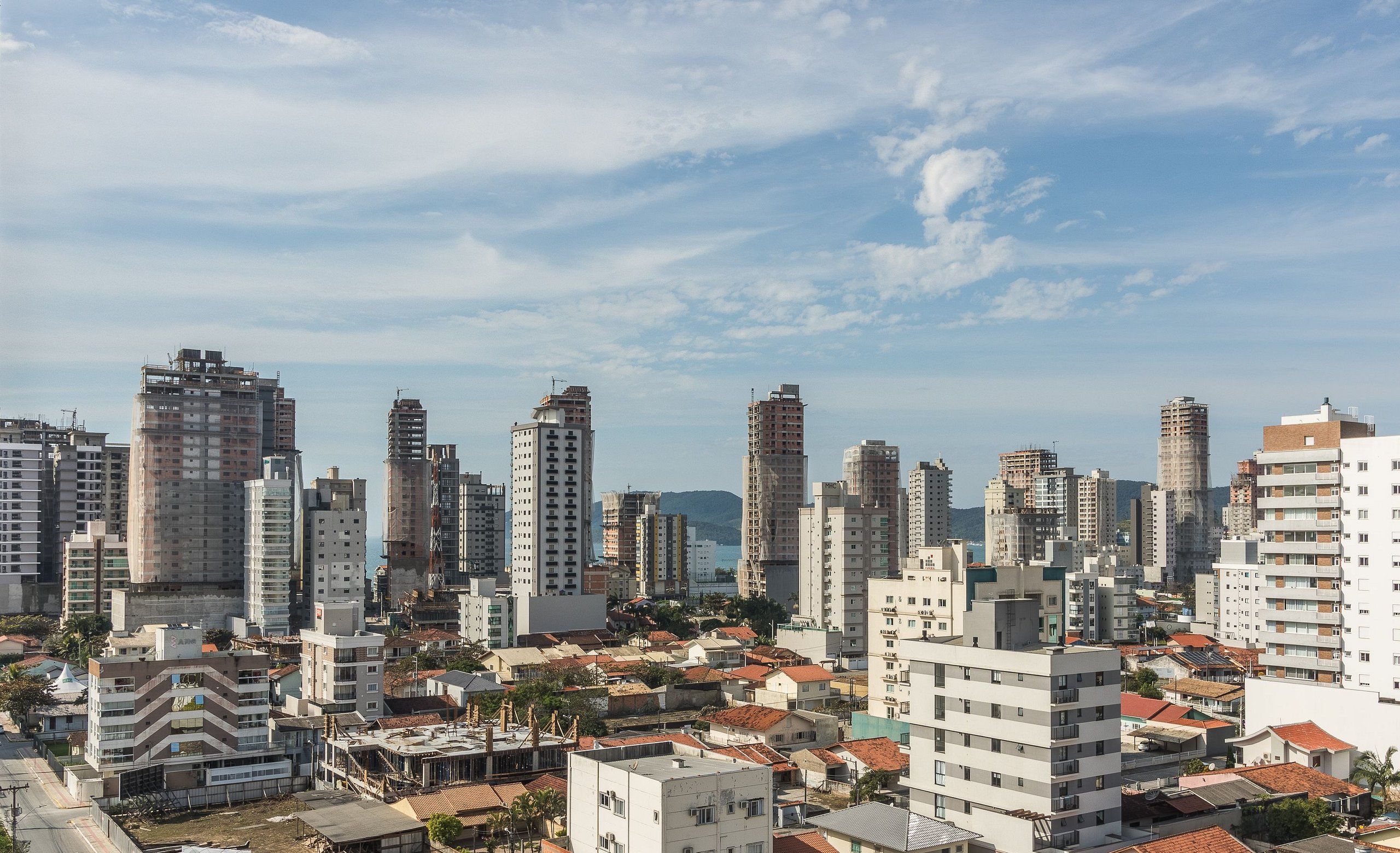 A cityscape with high-rise buildings, a mix of residential and commercial structures, and a clear sky.