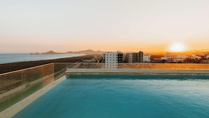 A swimming pool with a clear view of the ocean and buildings in the background. - Arch View Condo Cabo San Lucas • 4th Floor Rooftop Pool | 403 (Cabo San Lucas)