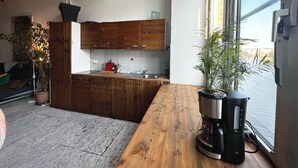 A modern kitchen with wooden cabinets, a large island, and a coffee machine. - Spacious 140 m² loft - perfect for families & friends! (Berlin)