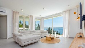 Un salon moderne avec un canapé, une table basse et une vue sur la mer.
