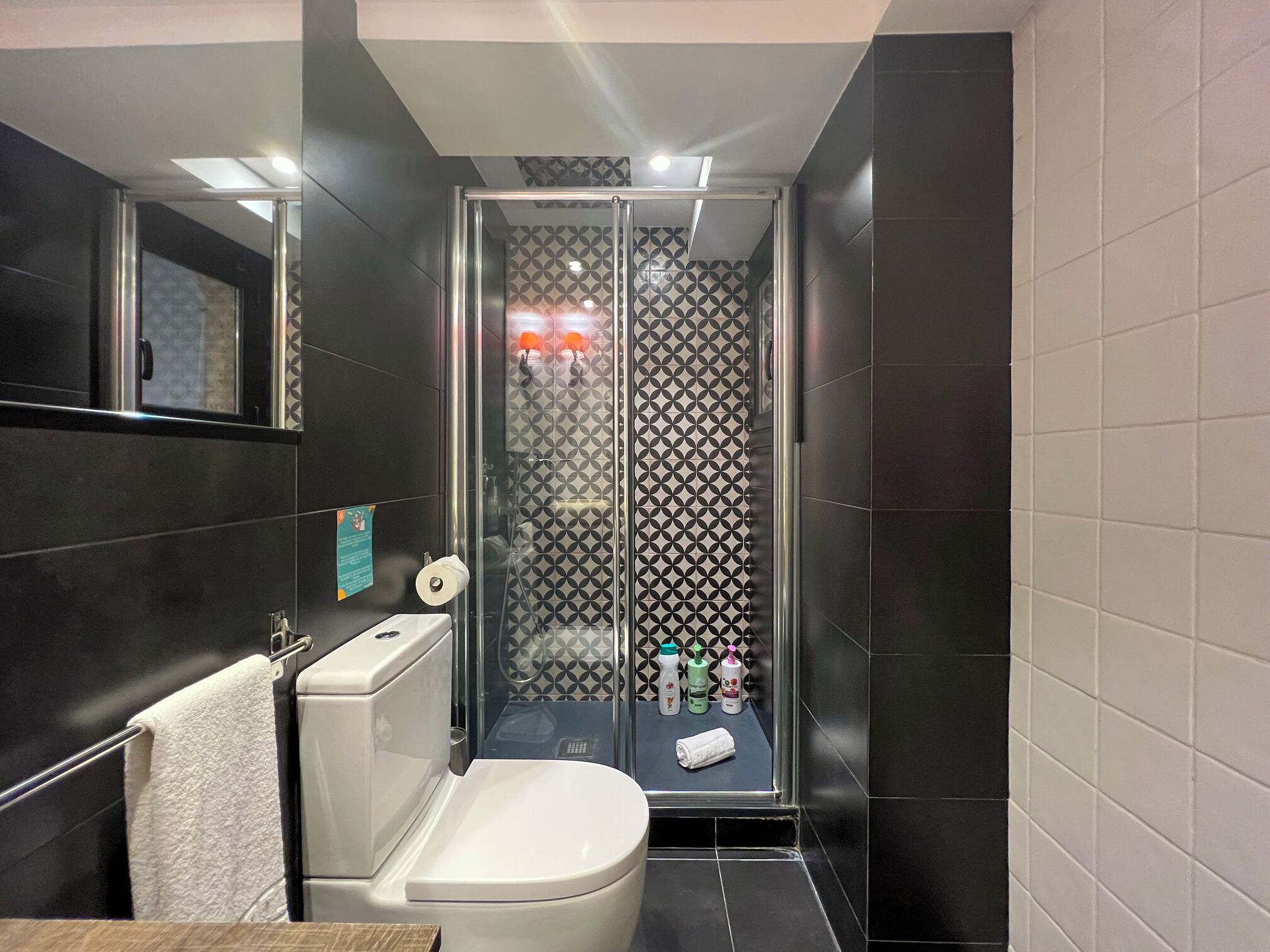 Ein modernes Badezimmer mit einer Glaskabine zur Dusche, einer Toilette und einem Waschbecken.