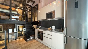 Una cocina moderna con electrodomésticos de acero inoxidable, horno empotrado y microondas.