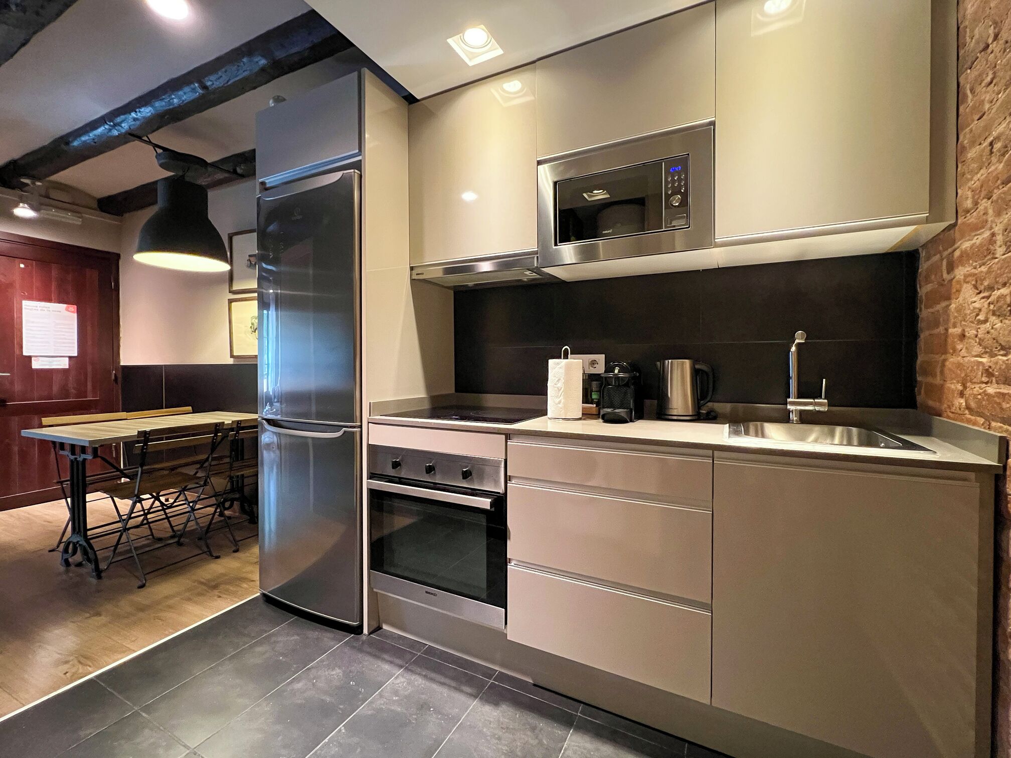 A modern kitchen with stainless steel appliances, a microwave, and a sink.
