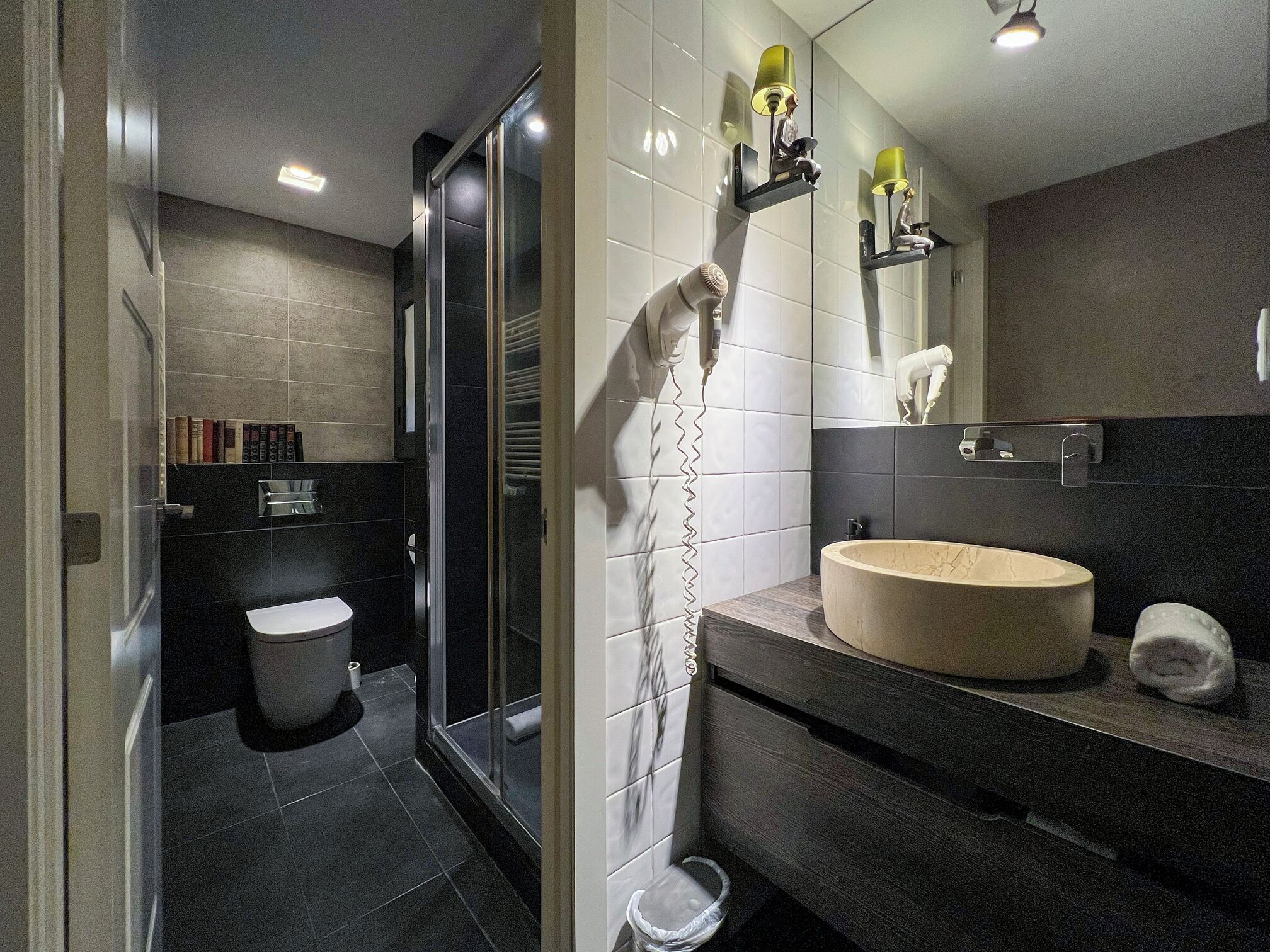 Ein modernes Badezimmer mit Duschkabine aus Glas, Toilette, Waschbecken mit Marmorbecken und Handtuchhalter.