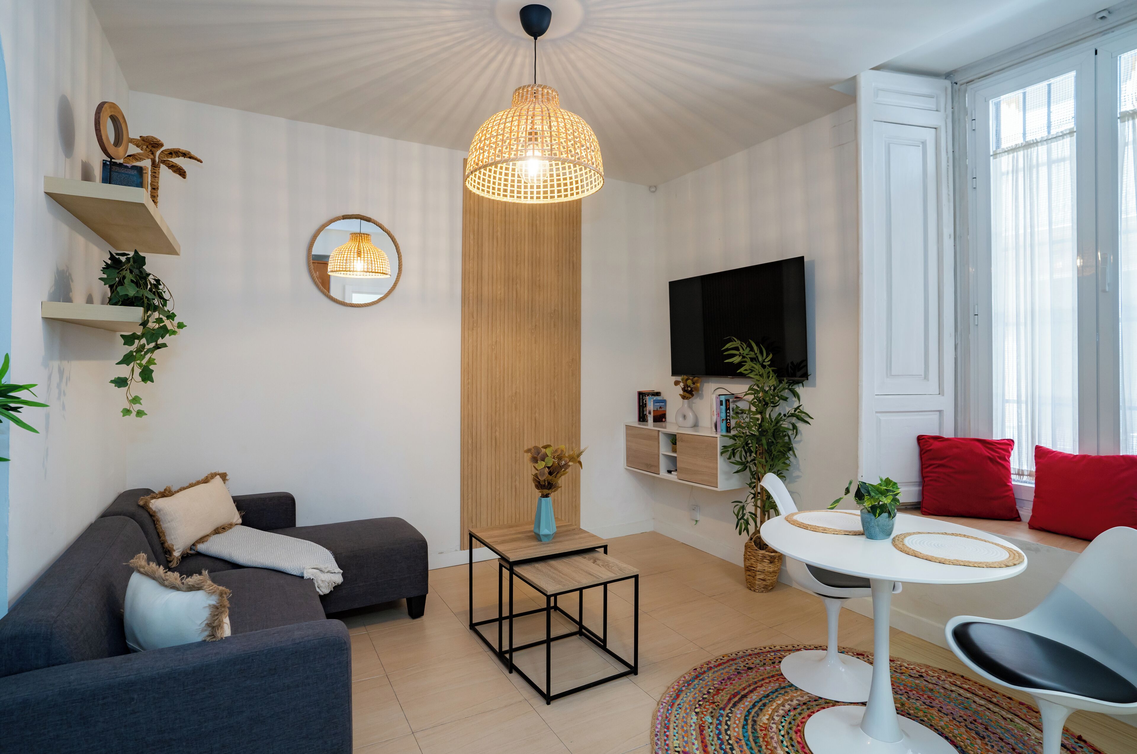Una sala de estar moderna con un sofá, una mesa de centro, un televisor y un comedor con sillas.