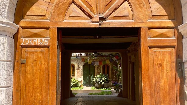 An arched wooden entrance with a sign reading "20KMB25". - Detached apartment in seventeenth-century building with indoor garden. (Verona)