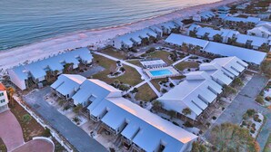 An aerial view of a resort with multiple buildings, a swimming pool, and a beach. - Ocean Breeze Beachfront SGI: Relaxing Escape for Families & Couples with Pool (St. George Island)