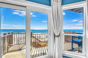 Un balcon avec vue sur la plage et l’océan.
