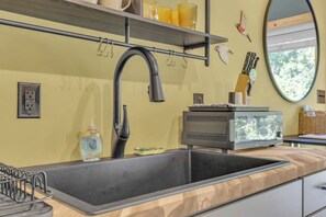 A kitchen with a modern faucet, a built-in sink, and a wooden countertop.