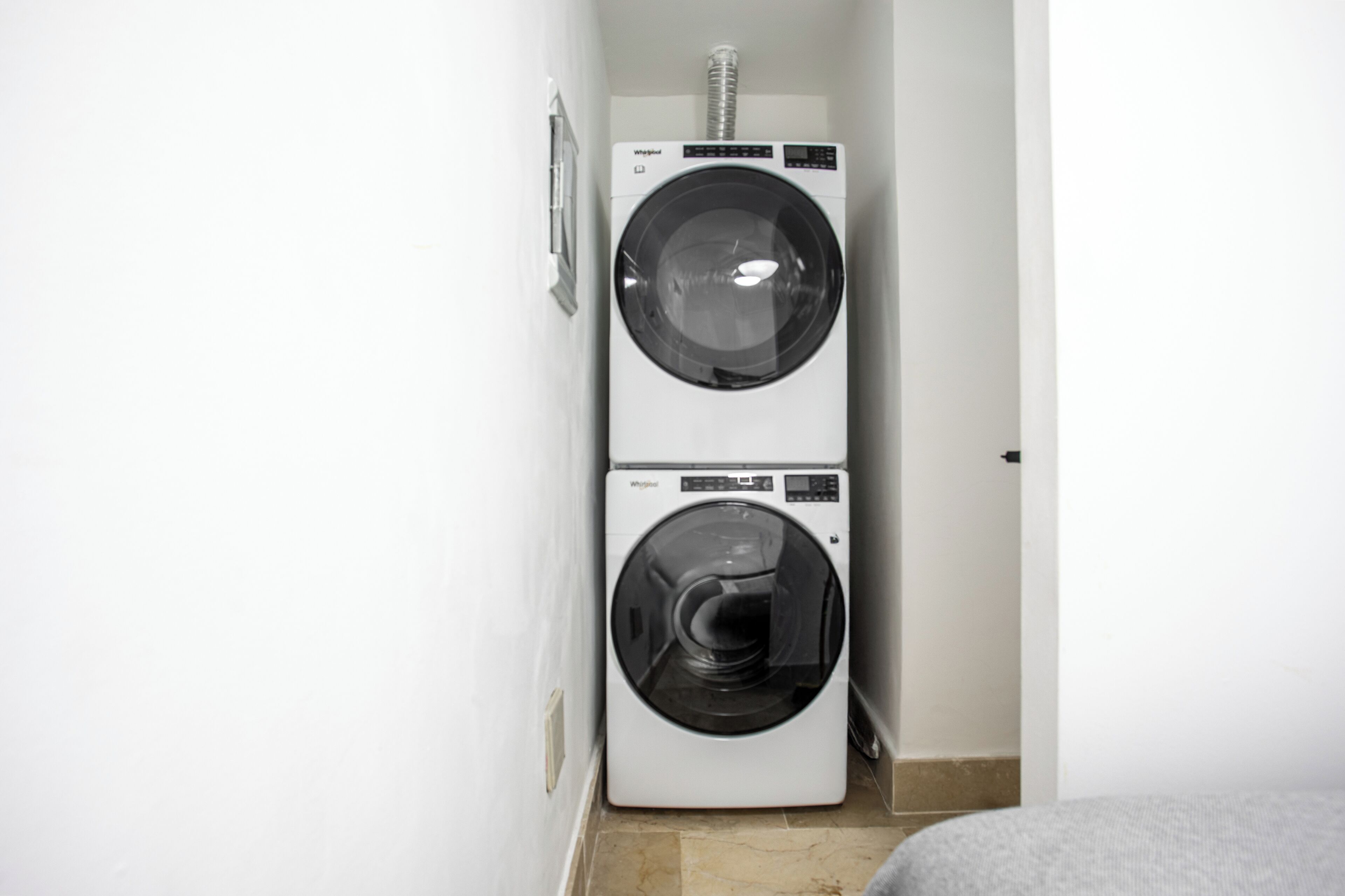 A laundry room with two stacked front-loading washing machines.