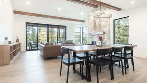 A spacious kitchen with a dining area, large windows, and a stone accent wall.