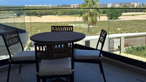A balcony with a round table and two chairs, overlooking a beach and cityscape. - Vermare 302 in Punta Cana (Punta Cana)