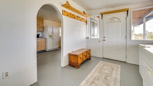 A hallway with a wooden bench, a coat rack, and a white door with a decorative glass panel. - 'Abigail's Ranch' - Dog-Friendly Dolan Springs Gem (Dolan Springs)