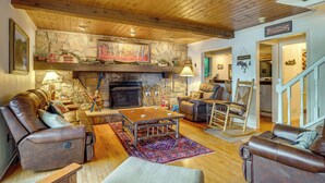 A cozy living room with a stone fireplace, leather sofas, and a wooden ceiling. - Beech Mt Lakefront Gem! Hot Tub, Kayaks, Billiards (Beech Mountain Lakes)