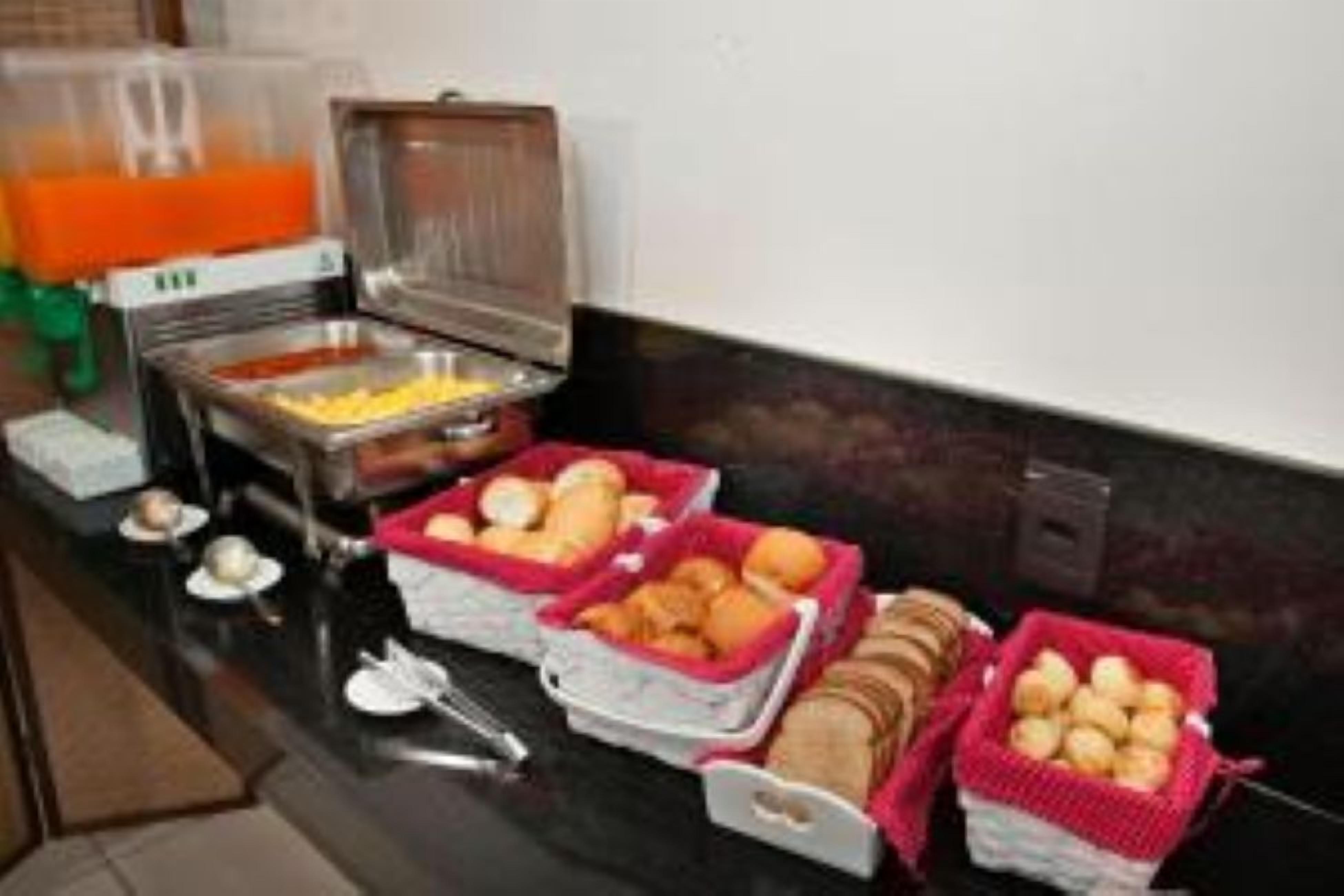 Montaje de bufé con diferentes alimentos en cestas, incluyendo lo que parece ser huevos, pasteles y posiblemente algunos platos de carne.