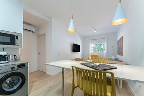 Une cuisine moderne équipée d’un lave-linge, d’un four à micro-ondes et d’une machine à café.