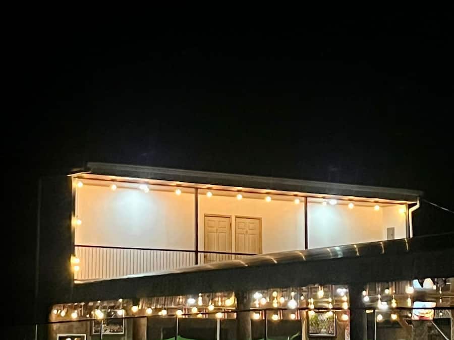 Um edifício moderno com varanda e luzes de festa.