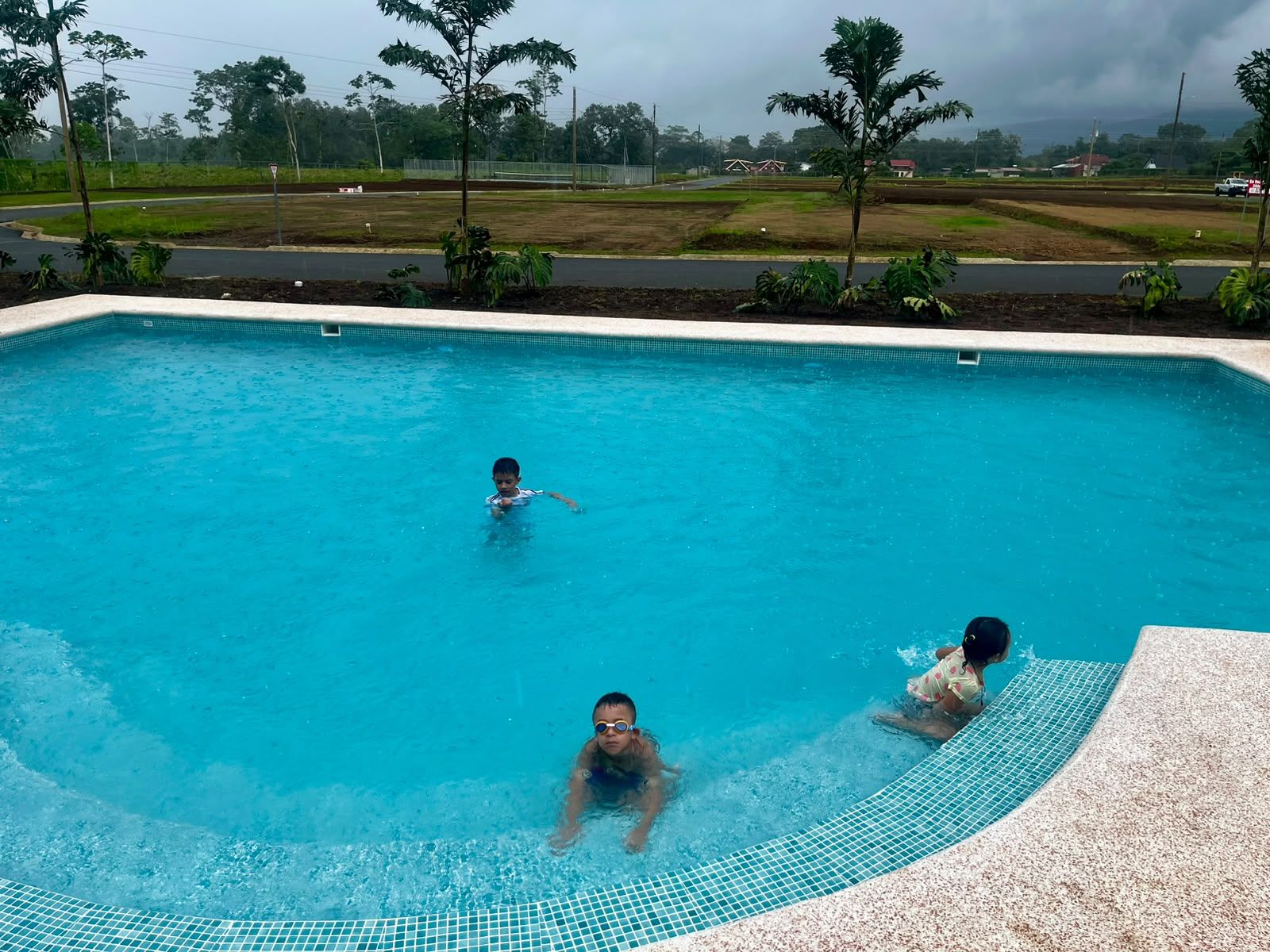 A swimming pool with three individuals in the water.