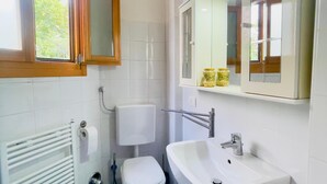 A bathroom with a toilet, sink, and mirror. - Apartment with balcony in historic building, 100m from the Arena (Verona)