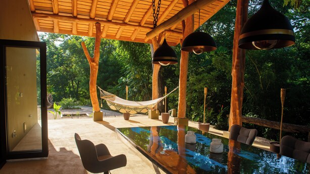 A serene outdoor pool area with a hammock, seating, and a wooden pergola. - Charming country house in  Playa Órganos Paquera in the middle of nature (Paquera)