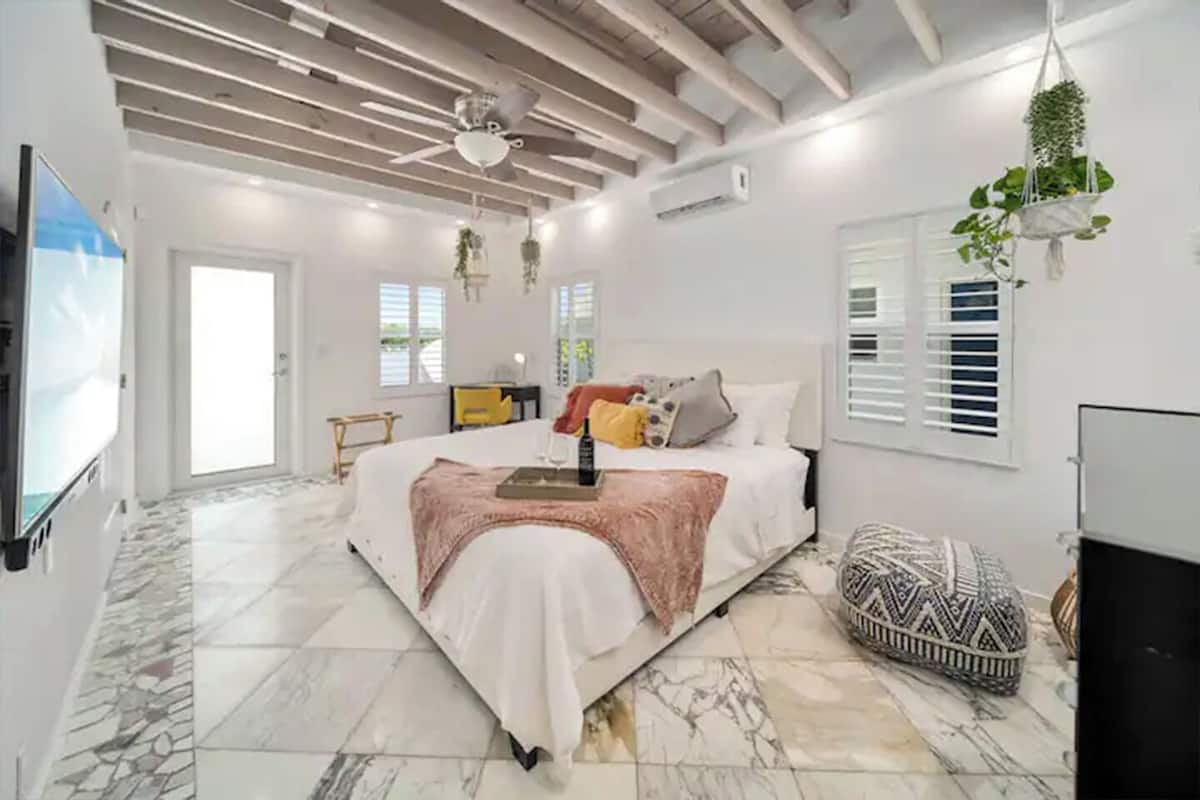 Un dormitorio amplio con una cama grande, un ventilador de techo y una televisión.