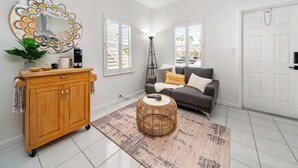 A modern living room with a grey sofa, a wooden cabinet, a floor lamp, and a patterned rug. - Waterways Komffy (Hollywood)