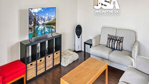 A modern living room with a television, sofa, and coffee table.