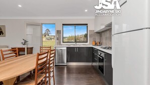 A modern kitchen with dark cabinets, a stainless steel dishwasher, and a gas stove.