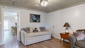 Ein Wohnzimmer mit einer Couch, einem Beistelltisch mit Lampe und einem Bild an der Wand.