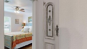 Ein Schlafzimmer mit einem Bett, einem Deckenventilator und einem Fenster.