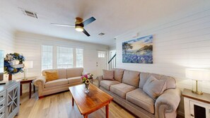 A living room with two sofas, a coffee table, and a painting on the wall. - Central Cottage Charm - Pet Friendly! Very Clean! (College Station)